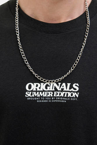T-shirt noir à manches courtes d'ORIGINALS BY JACK & JONES, avec une impression de texte blanche, porté avec une chaîne en argent.