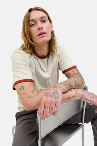 T-shirt écru à manches courtes d'ORIGINALS BY JACK & JONES, avec une patte brune et des tatouages sur les bras.