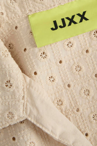 Blouse sans manches beige de JJXX, avec un motif floral ouvert et une étiquette claire.