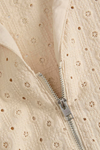 Blouse beige de JJXX avec des détails en dentelle et une fermeture éclair sur le devant.