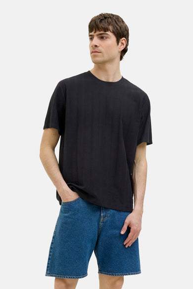 T-shirt noir à manches courtes de JJREBEL, porté avec des shorts en denim bleu.