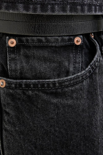 Jean délavé gris foncé de JACK & JONES JEANS INTELLIGENCE, avec une ceinture en cuir et des accents bronzés, en gros plan.