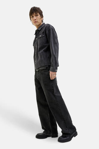 Modèle large de jeans denim gris foncé de JACK & JONES JEANS INTELLIGENCE, avec ce ce noir et des chaussures.