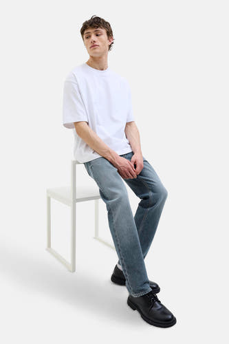 Jean tapered en denim bleu moyen de JACK & JONES JEANS INTELLIGENCE, associé à un T-shirt blanc et des chaussures noires.