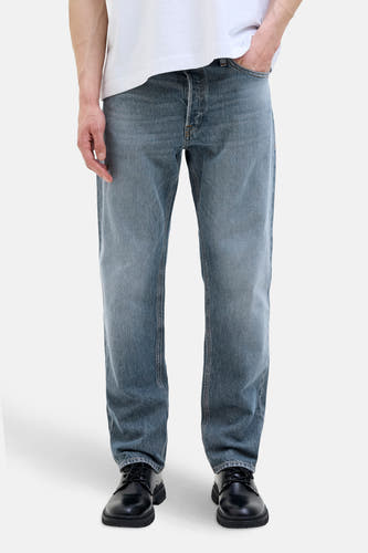 Jean tapered en denim bleu moyen de JACK & JONES JEANS INTELLIGENCE, porté avec un T-shirt blanc et des chaussures noires.