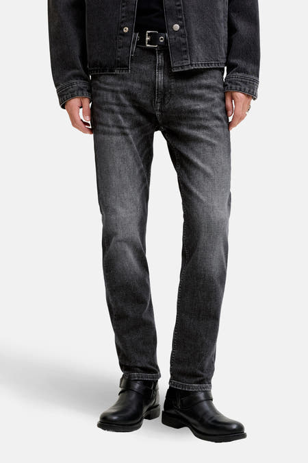Jean droit gris anthracite en denim de JACK & JONES JEANS INTELLIGENCE, associé à un T-shirt noir, un manteau et des bottes.