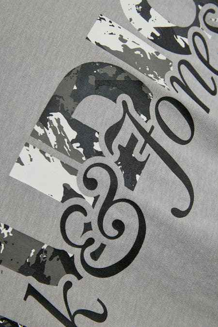 T-shirt gris à manches courtes de CORE BY JACK & JONES, avec une impression graphique en noir, gris et blanc.