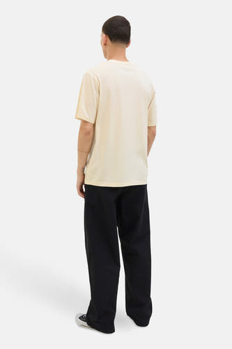 T-shirt jaune à manches courtes de CORE BY JACK & JONES, avec un pantalon noir et des baskets basses.
