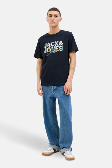 T-shirt bleu à manches courtes d'ORIGINALS BY JACK & JONES, avec une impression graphique, associé à des jeans larges et des baskets basses.