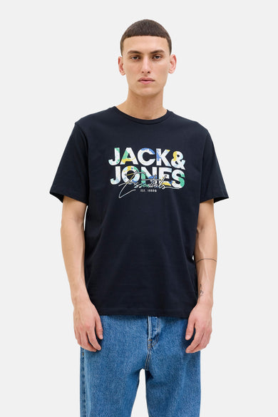 T-shirt bleu à manches courtes d'ORIGINALS BY JACK & JONES, avec une impression de logo colorée sur la devanture, porté avec un jeans bleu.
