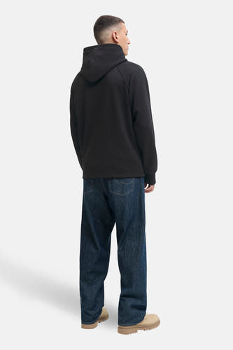 Gilet noir de CORE BY JACK & JONES, dos, associé à un pantalon large et des baskets beige.