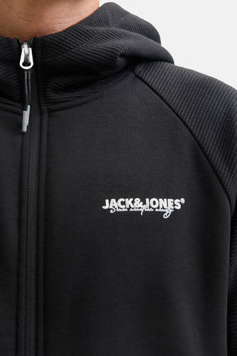 Gilet noir de CORE BY JACK & JONES, avec un logo sur la poitrine et une capuche à fermeture éclair.