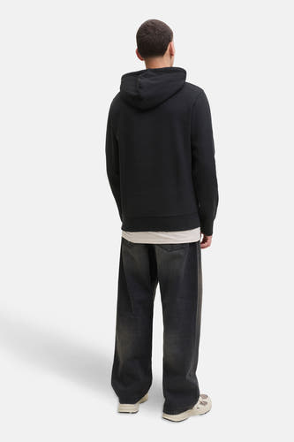 Pull noir avec capuche de CORE BY JACK & JONES, associé à des jeans gris foncé décontractés et des baskets blanches.