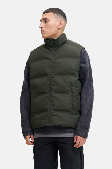 Gilet vert de ORIGINALS BY JACK & JONES, avec un pull grossier gris et un pantalon noir.