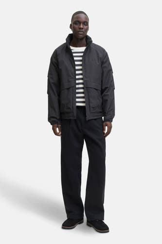 Manteau court noir de CORE BY JACK & JONES, détail de la manche avec poche et boutons.