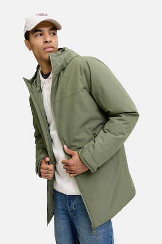 Veste courte verte d'ORIGINALS BY JACK & JONES, avec capuche, portée avec une polo blanche et des jeans.
