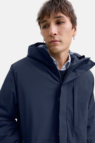 Veste bleue courte de CORE BY JACK & JONES, avec capuche et une chemise à rayures visible.