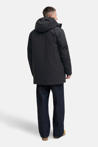 Manteau long noir d'ORIGINALS BY JACK & JONES, avec capuche, vu de dos, associé à des jeans larges et des chaussures beige.