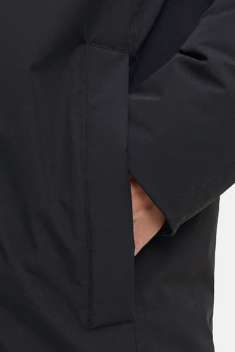 Manteau long noir d'ORIGINALS BY JACK & JONES, avec une main dans la poche et une texture lisse.