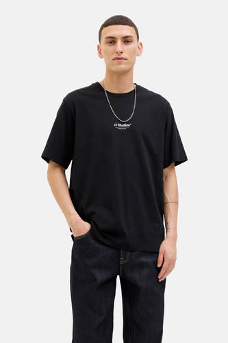 T-shirt noir à manches courtes de CORE BY JACK & JONES, avec une chaîne argentée et des jeans foncés.
