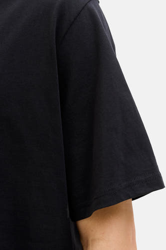 T-shirt noir à manches courtes de CORE BY JACK & JONES, gros plan sur la manche et le haut du bras.