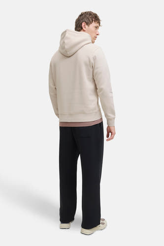 Gilet beige avec capuche de CORE BY JACK & JONES, vu par derrière, avec un pantalon noir et des baskets crème.
