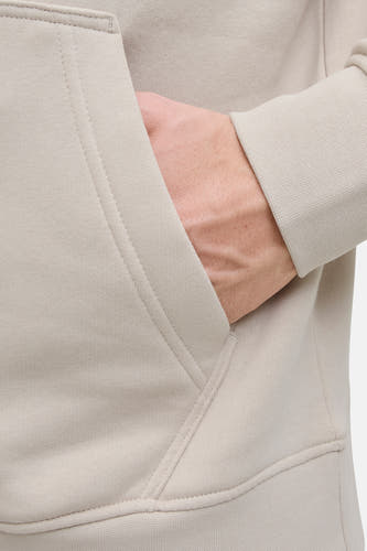 Gilet beige avec capuche de CORE BY JACK & JONES, avec une main dans la poche et des manches longues.