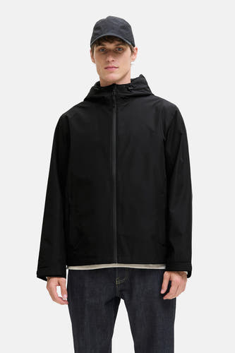 Manteau court noir d'ORIGINALS BY JACK & JONES, avec capuche, associé à un jean foncé et une casquette.