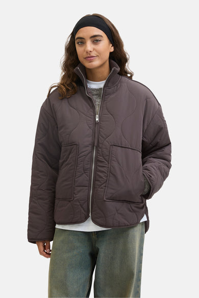 Manteau court brun de JJXX, avec un motif bouclé et porté sur une chemise et des jeans larges.