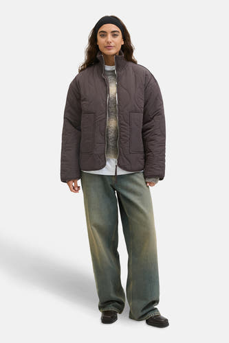 Manteau court brun de JJXX, avec un motif bouclé et porté sur une chemise et des jeans larges.