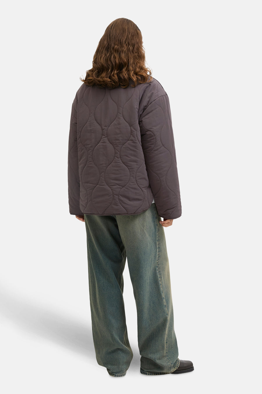 Manteau court brun de JJXX, avec un motif en duvet, porté avec des jeans larges et des chaussures noires.