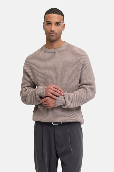 Gilet rond beige de PREMIUM par JACK & JONES, avec des manches longues et un pantalon gris.