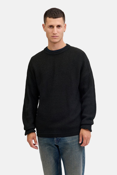 Pull-over noir avec col rond de PREMIUM by JACK & JONES, porté avec des jeans bleus.