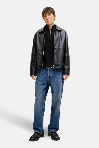 Pull-over noir à fermeture éclair de PREMIUM par JACK & JONES, porté avec une veste en cuir, des jeans et des chaussures noires.