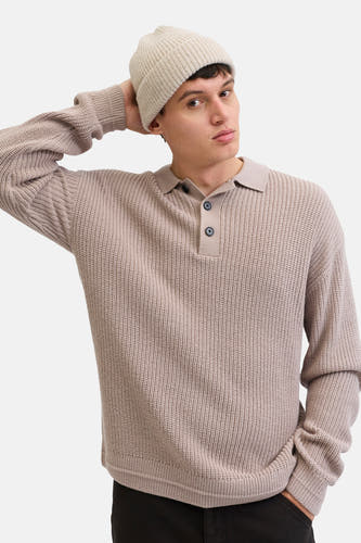 Gilet beige à col V de PREMIUM par JACK & JONES, avec une texture tricotée et une fermeture à boutons, associé à un bonnet tricoté.