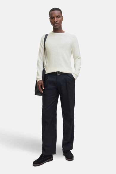 Pull blanc à col rond de CORE BY JACK & JONES, en tricots horizontaux, porté avec un pantalon noir et des chaussures.