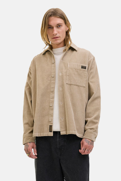 Chemise en velours côtelé marron de PREMIUM BLUE par JACK & JONES, avec poche poitrine et portée sur une chemise blanche.