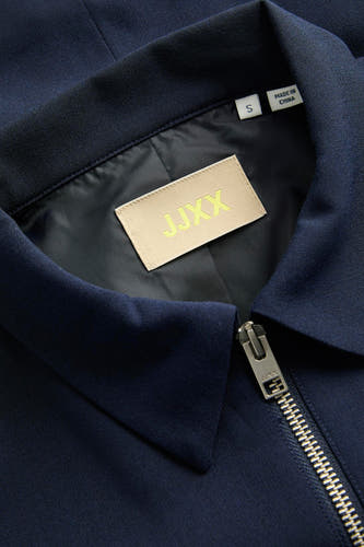Blouse bleue de JJXX, avec col et fermeture éclair argentée.