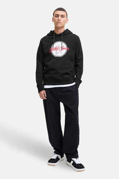 Pull-over noir avec capuche d'ORIGINALS par JACK & JONES, avec un logo imprimé sur la partie avant, associé à un T-shirt blanc et une pantalon noir.