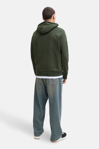 Pull-over vert de capotSS BY JACK & & J,, vu vu de derrière, associé à un T-shirt blanc et des jeans larges.