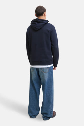 Pull-over bleu avec capuche d'ORIGINALS BY JACK & JONES, vu de dos, associé à des jeans larges et des chaussures marron.