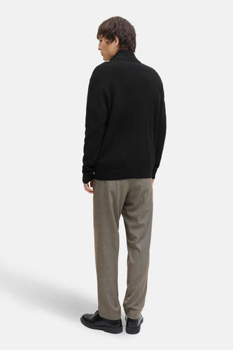 Gilet noir de CORE BY JACK & JONES, avec des manches longues, un col haut, associé à un pantalon marron et des chaussures noires.