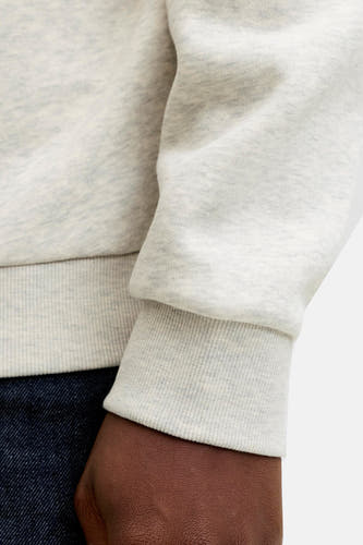 Pull-over gris d'ORIGINALS BY JACK & JONES, gros plan sur le manche avec une bordure côtelée et un aperçu de denim.