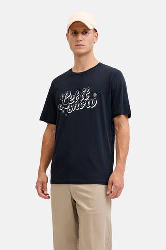 T-shirt bleu marine à manches courtes d'ORIGINALS BY JACK & JONES, avec un imprimé 'Let it snow' et porté avec un pantalon beige et des baskets blanches.