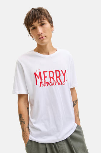 T-shirt blanc à manches courtes d'ORIGINALS BY JACK & JONES, avec une impression "Joyeux Noël" rouge, porté avec un pantalon kaki.