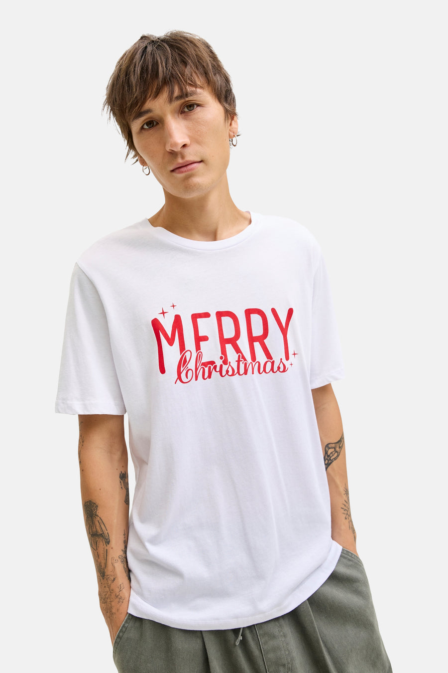 Een man met een wit t-shirt met de tekst "Merry Christmas" in rood.