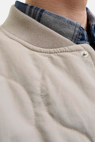 Beige, manteau court d'ORIGINALS BY JACK & JONES, avec col à bord côte et bouton pression visible, porté sur un chemisier rayé.