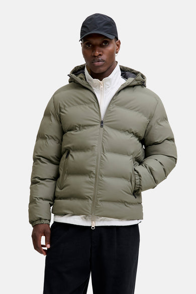 Manteau vert court de CORE BY JACK & JONES, avec capuche et fermeture éclair, associé à un pantalon noir et une chemise blanche.