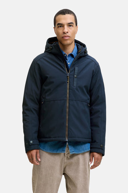 Veste courte bleue de PREMIUM BLUE par JACK & JONES, portée sur une chemise en denim avec un pantalon beige.