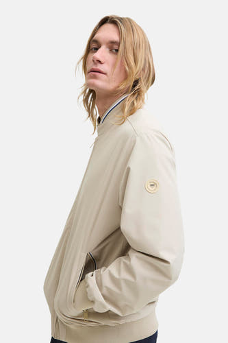 Manteau court beige d'ORIGINALS BY JACK & JONES, avec une étiquette ronde de la marque sur le manche et un col côtelé.